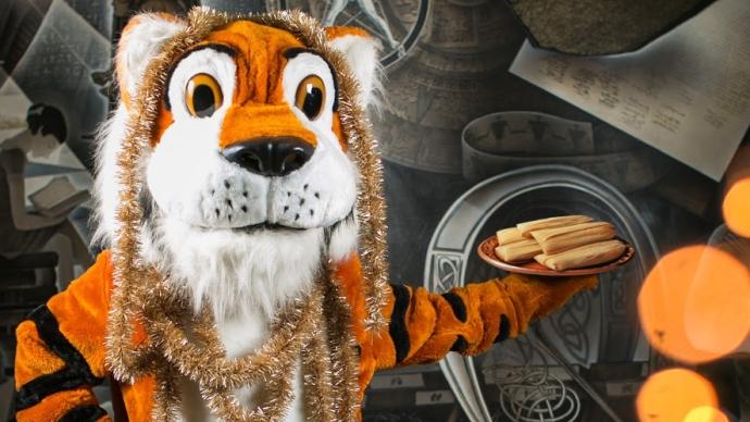 a festive LeeRoy the Tiger holds a platter of Tamales