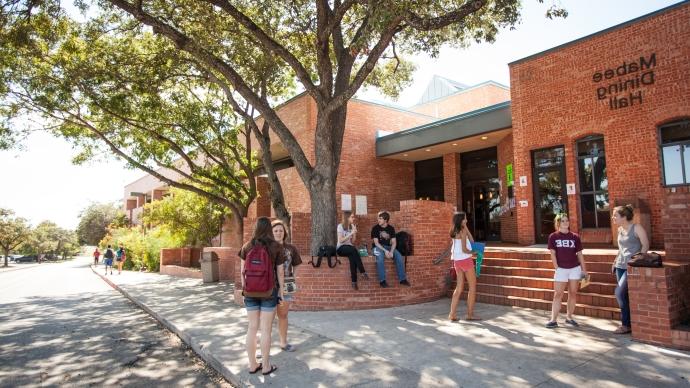 Mabee Dining Hall outside entrance with several students around the building