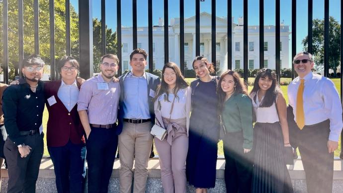 Eight 澳门金沙线上赌博官网 LOFT students pose in front the White House with Juan Sepulveda