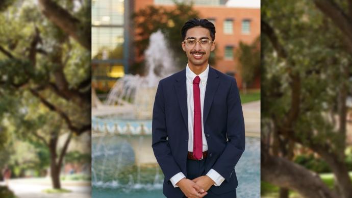 Hugo Sanchez '24 stands in a suit in front of Miller Fountain