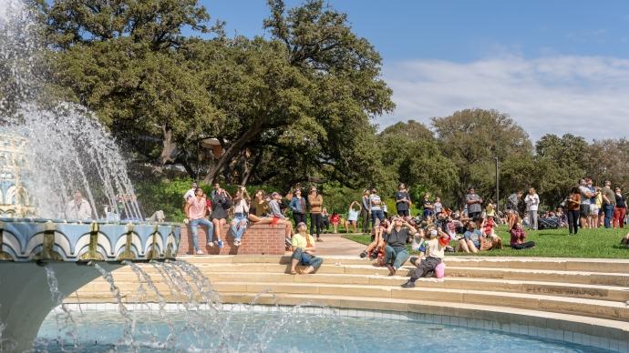 a large group of eclipse-watchers gather by Miller Fountain