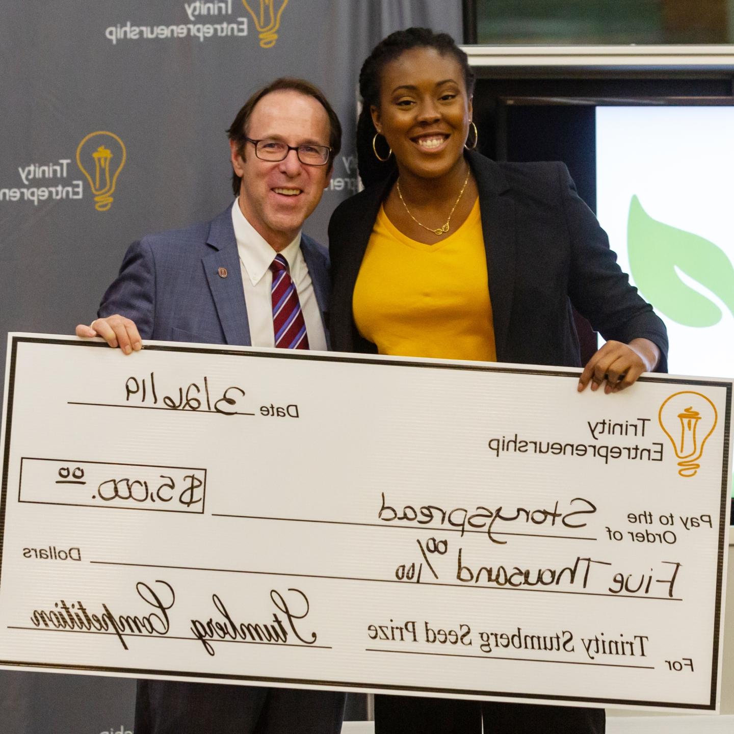 Chikanma Ibeh and Danny Anderson pose holding a $5k big check