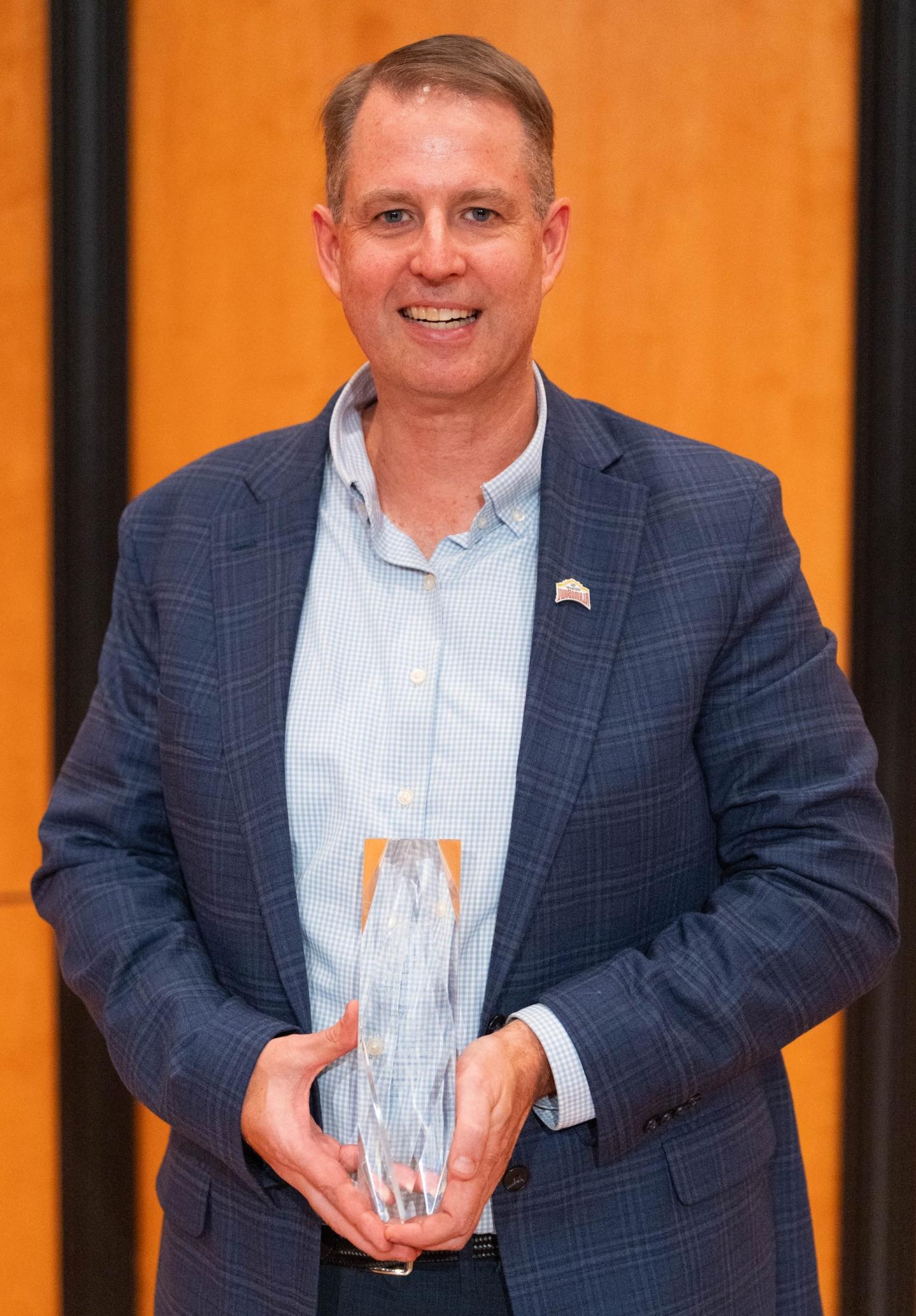 Photo of Rick Hill '91 holding an 校友 Award