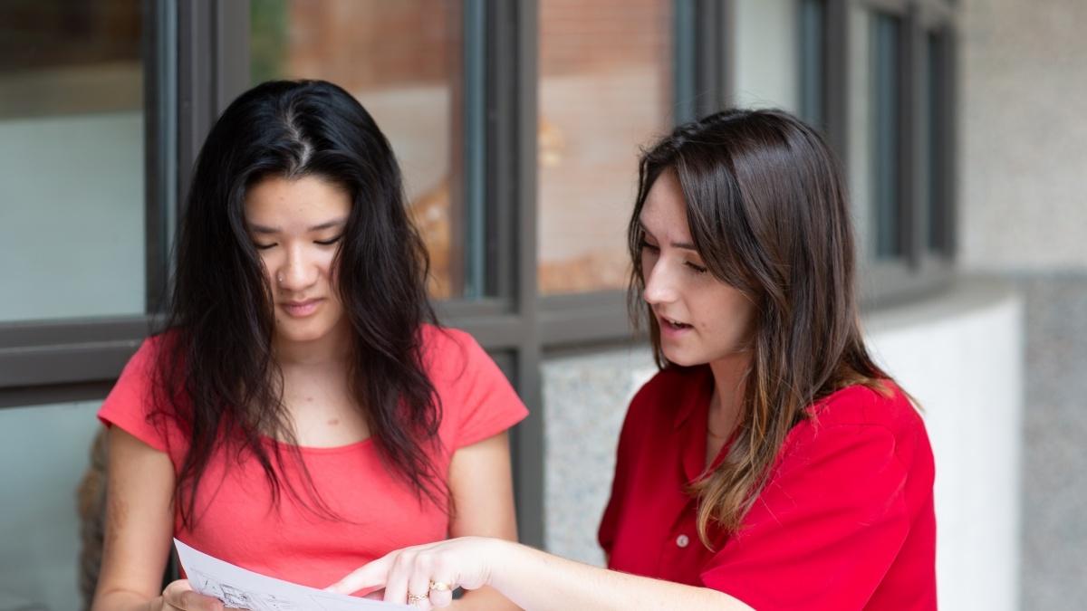 Students look over document together.