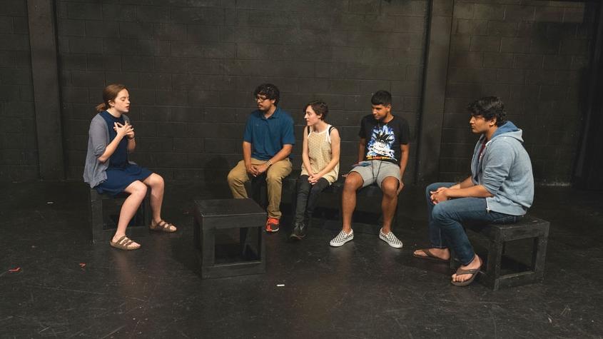 Julia Grace Palmer, seated, talks to other students during the performance. 